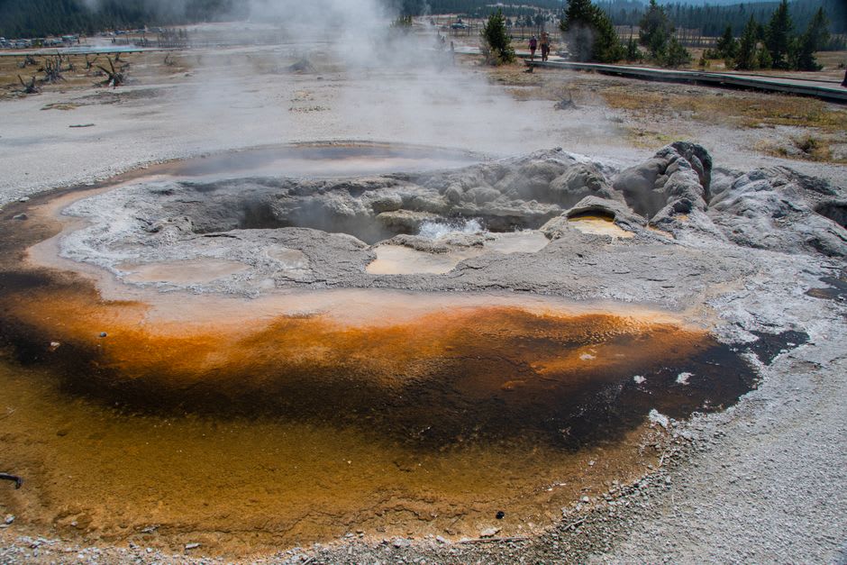 Steaming thermal pool bordered by moss-covered volcanic rock at Fuentes Georginas