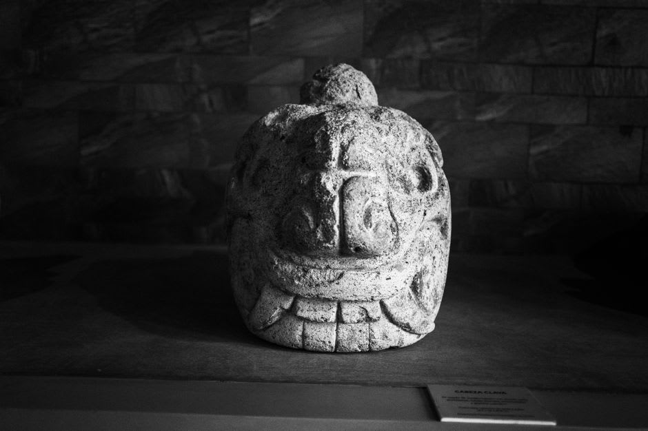 Rounded potbelly stone sculptures displayed inside the small archaeological museum of La Democracia