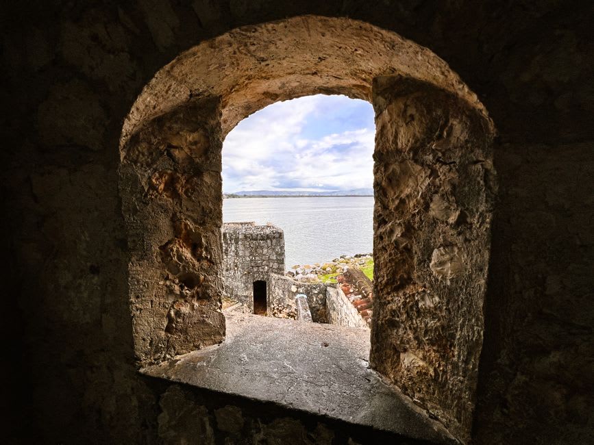 The stone ramparts and cannons of Castillo de San Felipe de Lara overlooking the calm waters of Lago de Izabal