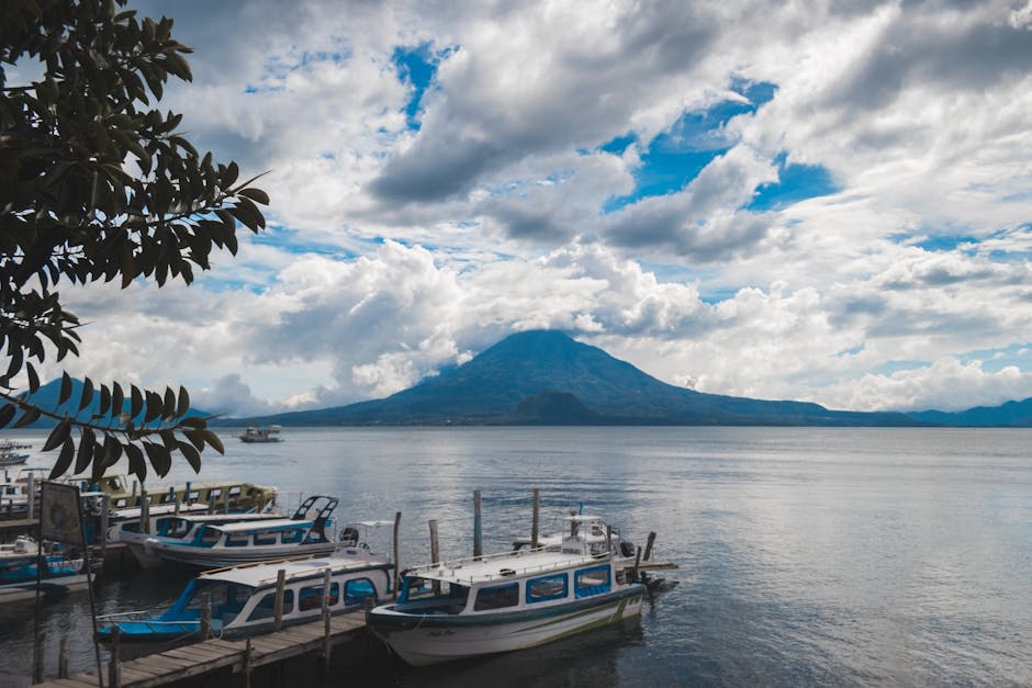 Panoramic view of the highland lake from a hillside trail with volcanic peaks in the distance