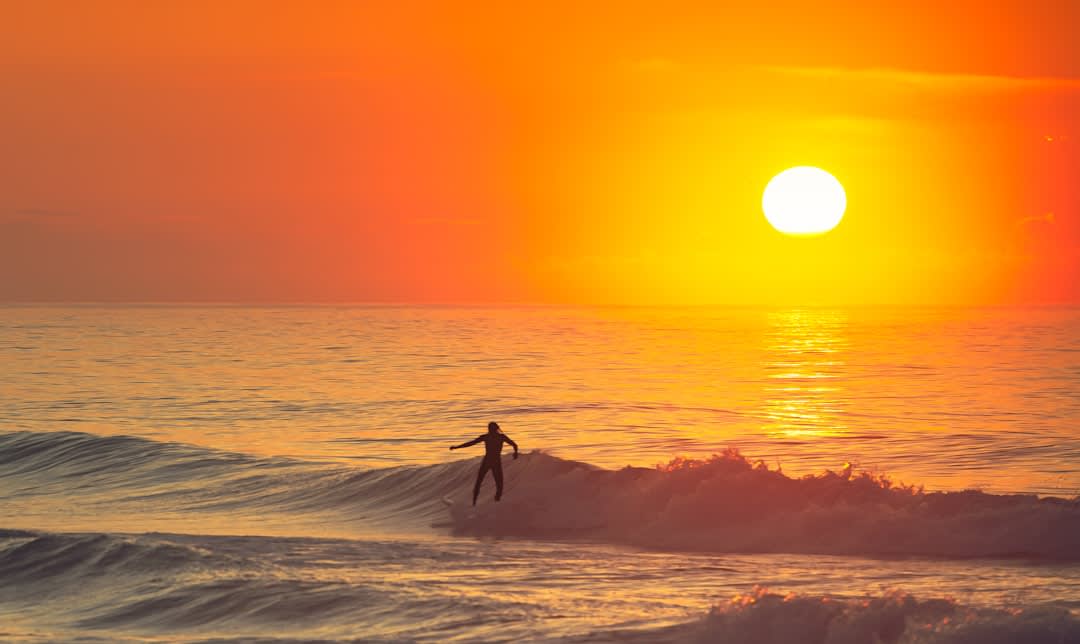 Fisherman pulling a net from the surf at dawn on the black sand of Las Lisas