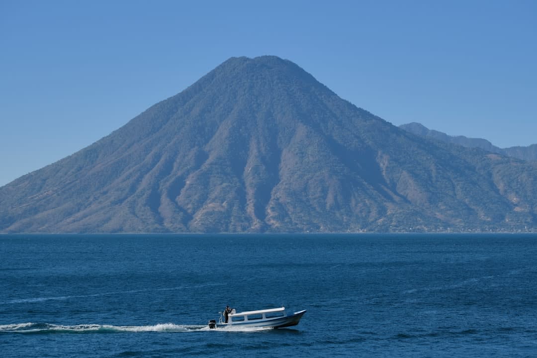 Wooden lanchas docked at the Panajachel pier with the volcanoes visible across the lake