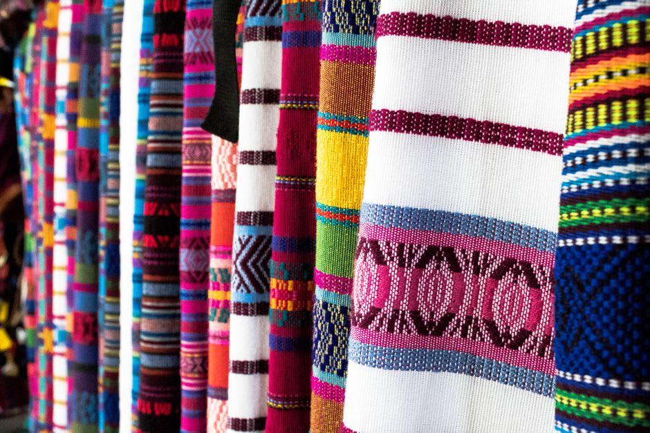 Woman tying off sections of thread for jaspé dyeing in a courtyard workshop in Salcajá