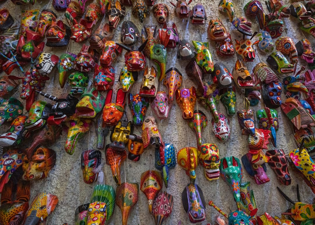 Bougies colorées et offrandes de bouteilles de rhum disposées au sol près d'un autel de sanctuaire à San Andrés Itzapa