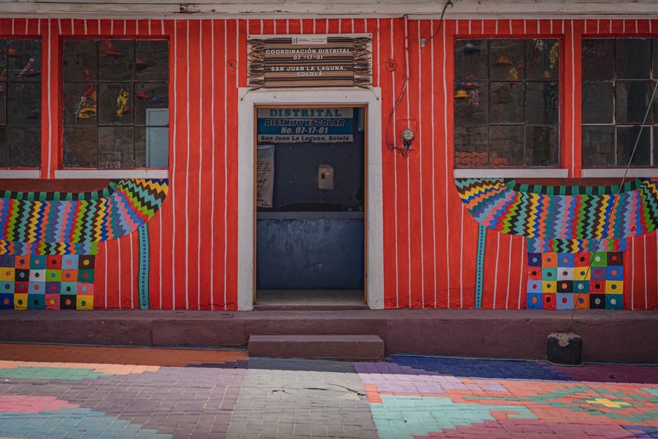 Mural of Maya symbolism painted across a building facade in San Juan La Laguna