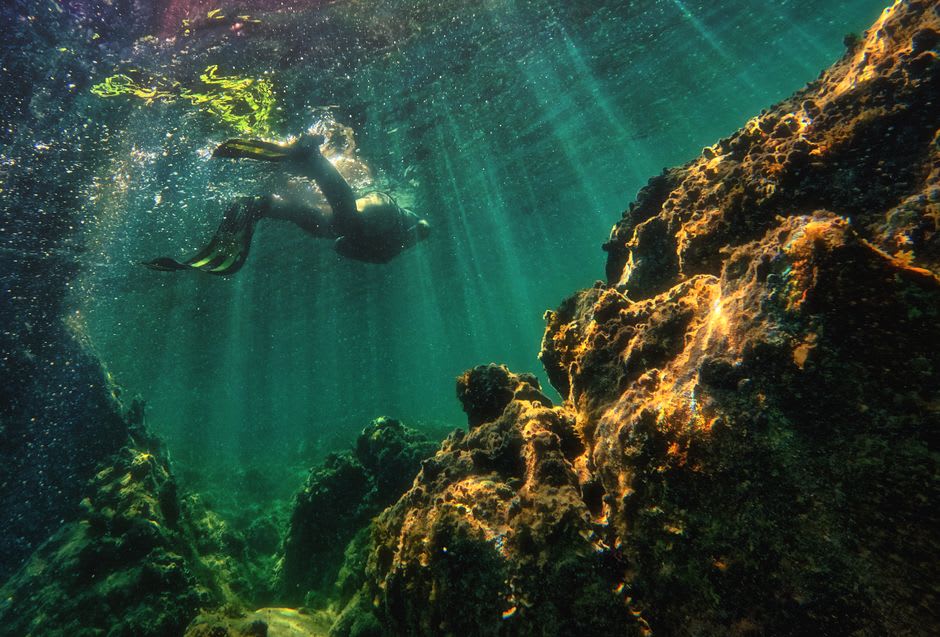 Scuba diver descending into the clear volcanic water of Lake Atitlán near Santa Cruz La Laguna