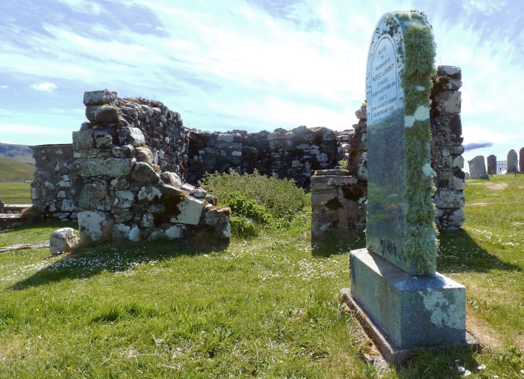 A solitary sacrificial altar stone on the main plaza of Zaculeu with pine forest and cloud-covered hills in the distance