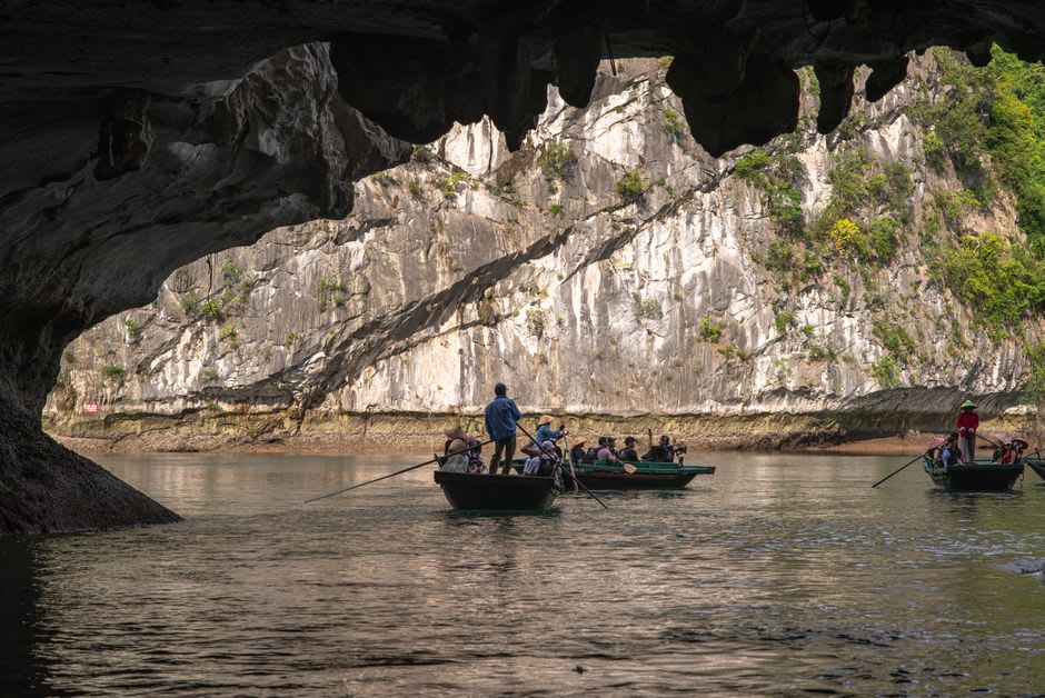 Boat drifting beneath the towering natural stone arch at Getu River