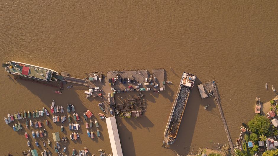 Wooden ferry stelling on the Berbice River with boats moored at New Amsterdam