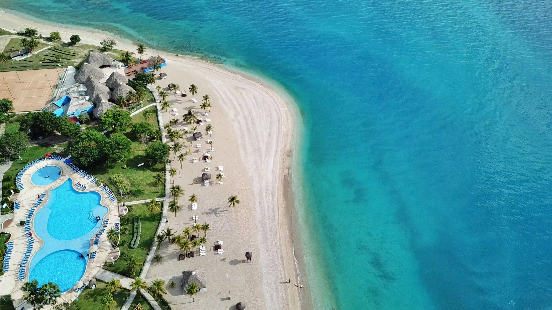 Balcones de hierro forjado y fachadas coloniales descascaradas en una calle soleada de Cap-Haïtien