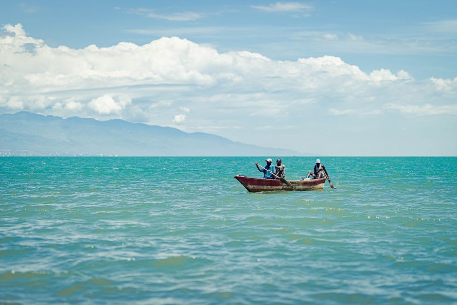 Small wooden fishing boats anchored in a sheltered cove on Île de la Tortue