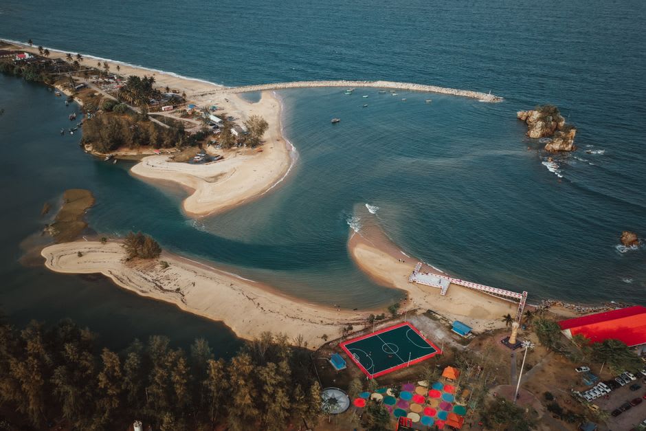 A quiet stretch of artificial beach on Tuần Châu Island with karst islands visible offshore