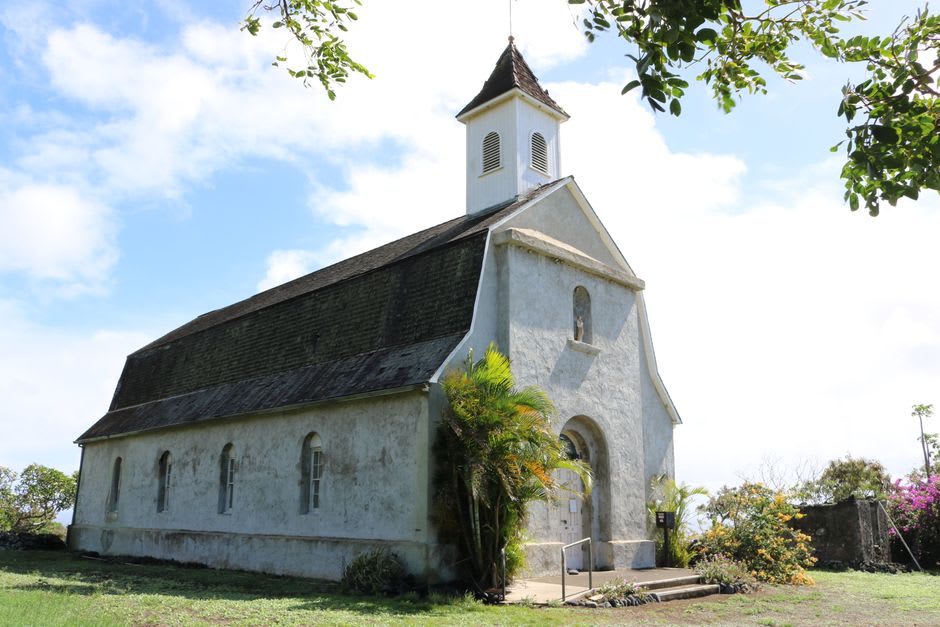 Intérieur de la petite église en bois construite par le Père Damien dans la colonie de Kalaupapa, bancs simples et lumière filtrant par des fenêtres nues