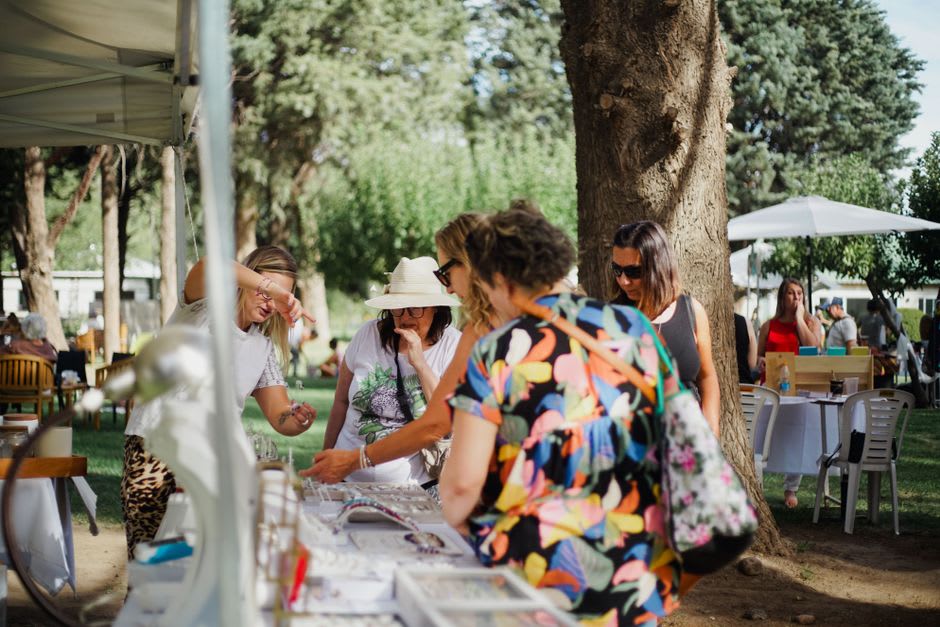Rassemblement communautaire avec un stand de shave ice et des habitants à l'ombre des pins de Dole Park