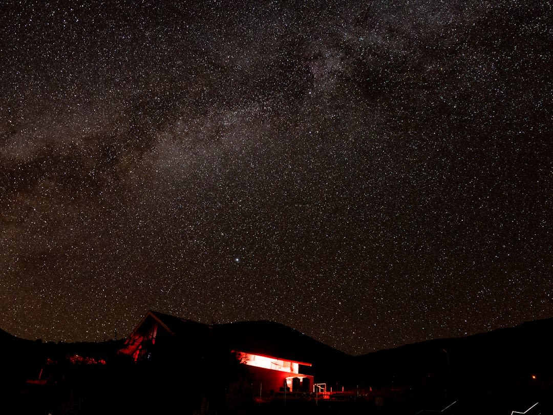 Mauna Kea's red cinder summit slopes with snow patches and observatory domes in the distance