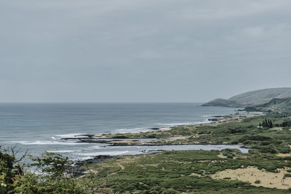 Shallow reddish clay salt pans used for traditional Hawaiian salt harvesting near Salt Pond Beach
