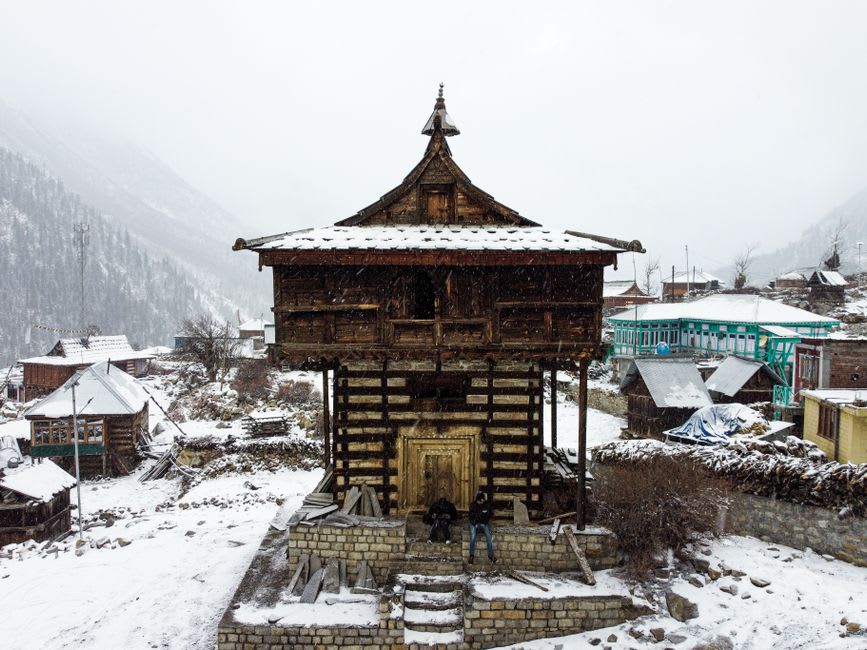 Wooden houses of Chitkul village with mountains rising above the Baspa River