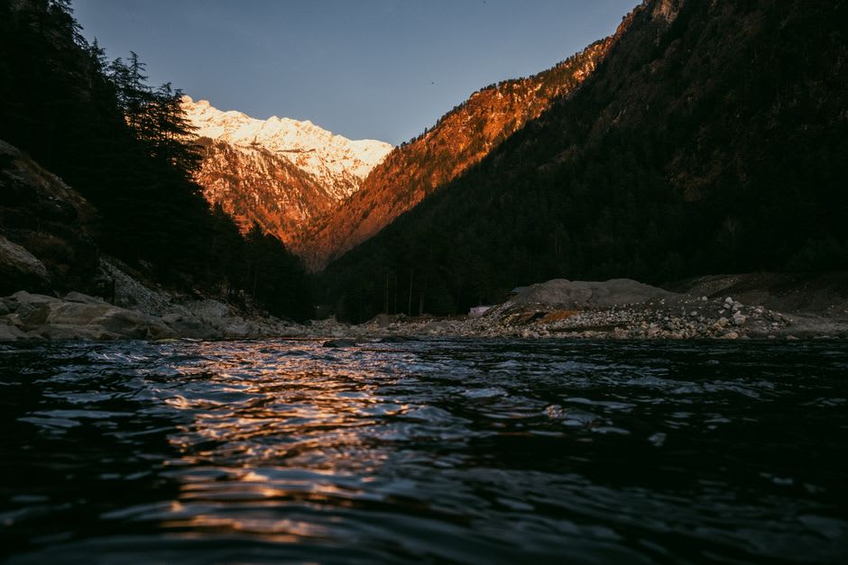 Wooden houses of Chitkul village with mountains rising above the Baspa River
