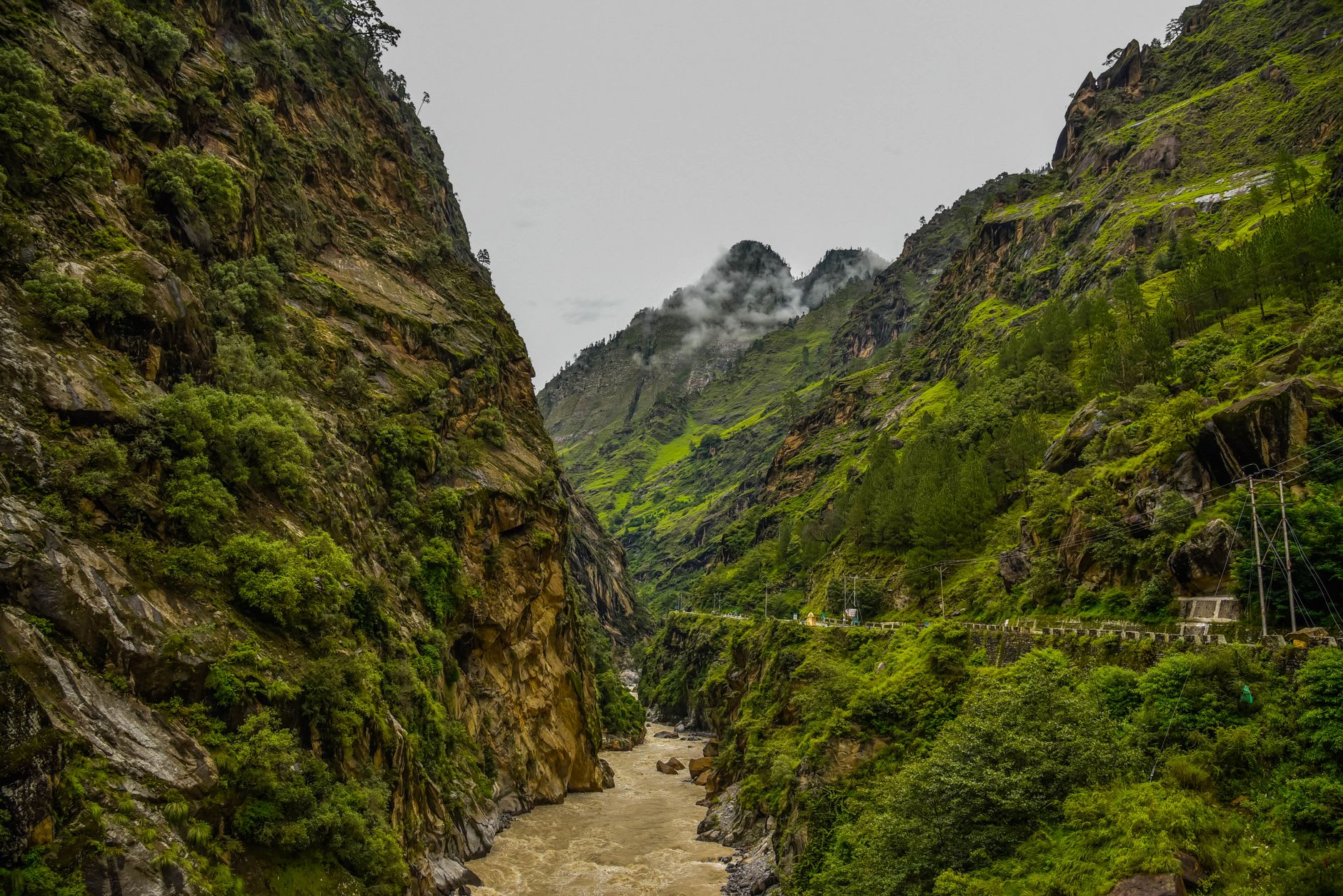 The seven-storey wooden Kamru Fort above Sangla village with carved balconies and the green valley floor stretching wide below it