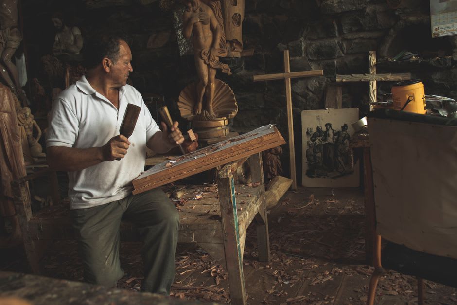 Un artisan menuisier sculptant des meubles à la main dans l'encadrure d'un atelier à Valle de Ángeles