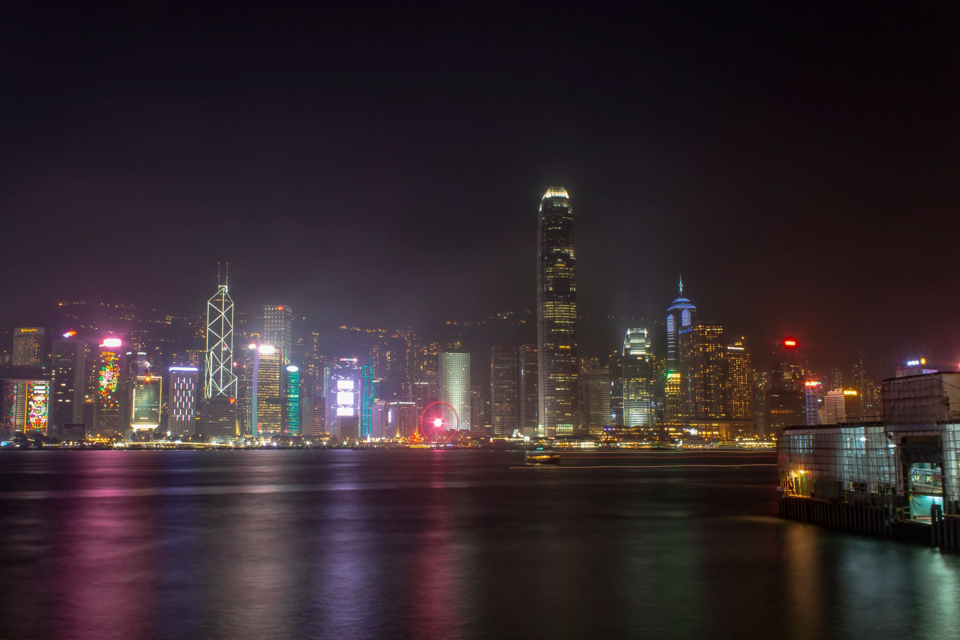 L'intérieur d'un restaurant de nouilles nocturne de Causeway Bay, de la vapeur s'élevant des bols de soupe sous la lumière jaune, des tables pleines à minuit