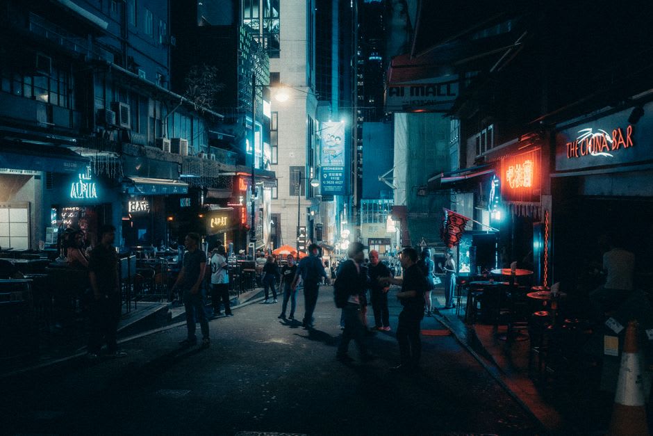 Camareros sirviendo bebidas a una multitud abarrotada dentro de un bar de Lan Kwai Fong