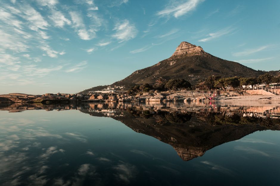 El empinado sendero rocoso que sube hacia la cumbre de Lion Rock, con las densas torres de Kowloon visibles entre los huecos de los árboles abajo