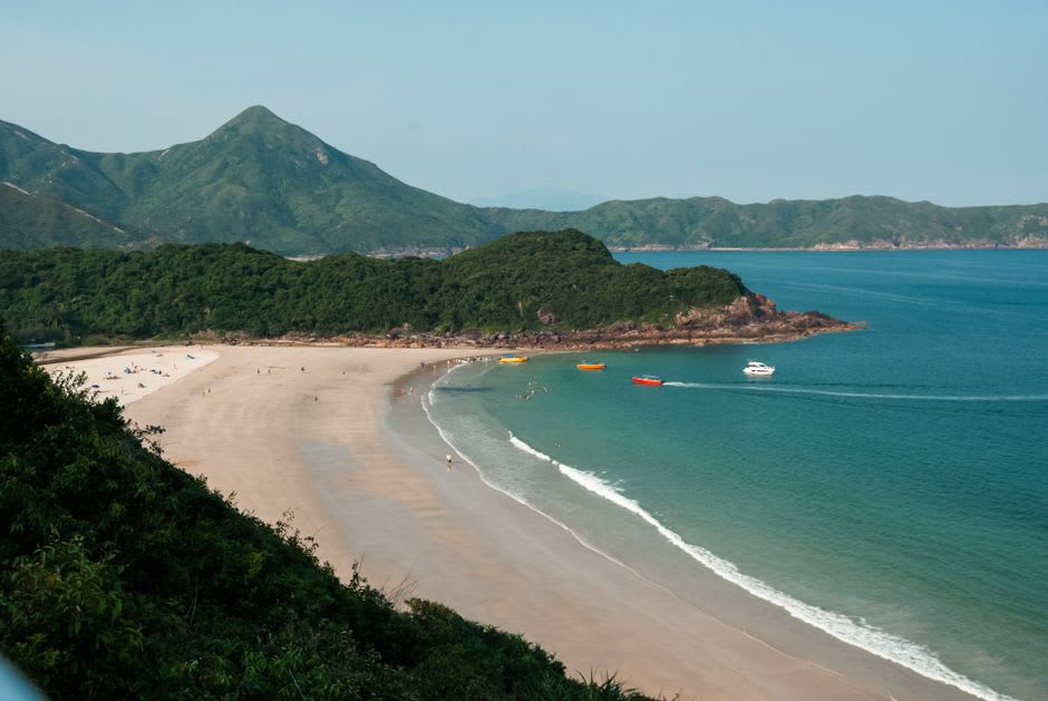 Des bateaux de pêche et des sampans amarrés le long de la promenade du front de mer de Sai Kung à l'heure dorée