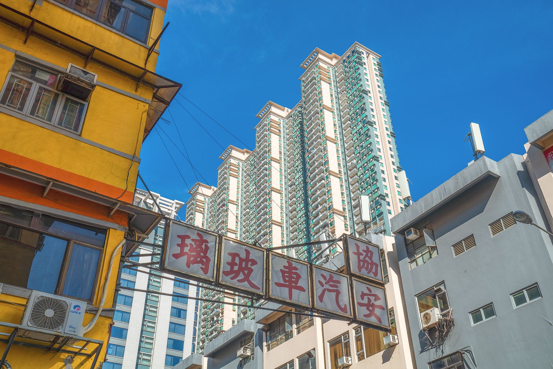 A row of Sham Shui Po electronics stalls with components and gadgets spilling out onto the pavement under fluorescent lights