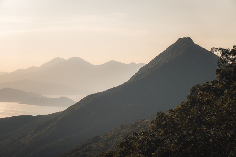 The steep rocky scramble near the summit of Sharp Peak, hikers picking their way up loose stone with the coastline receding below