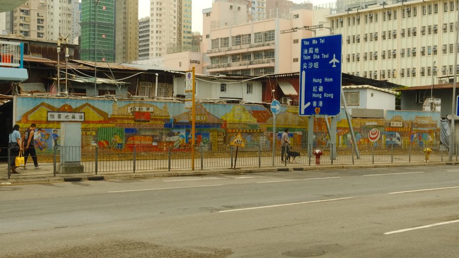 Green-shuttered tong lau buildings of the fruit market lit by streetlamps in the pre-dawn quiet
