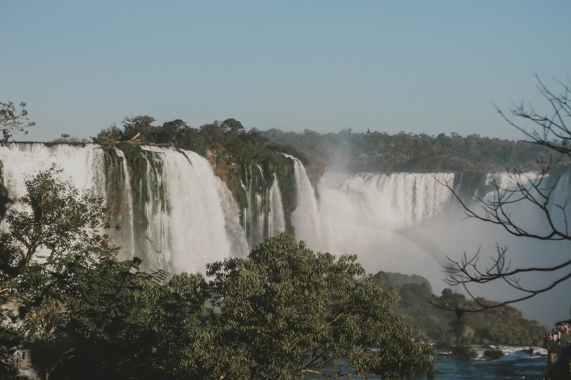Vista desde arriba mirando hacia abajo al Salto Mbiguá y las cataratas circundantes con la copa de la selva debajo y la niebla ascendiendo