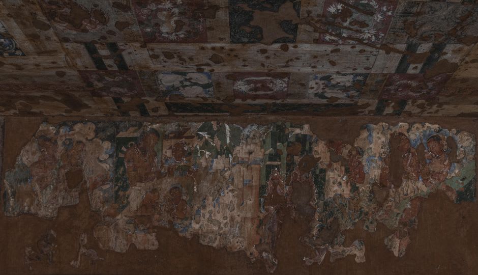A torch-lit Buddhist mural of a bodhisattva inside one of Ajanta's dark cave interiors