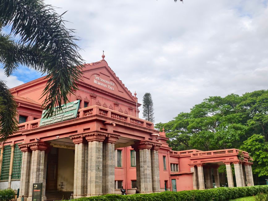 Cubbon Park's tree-lined avenue with the red Gothic High Court building visible in the distance