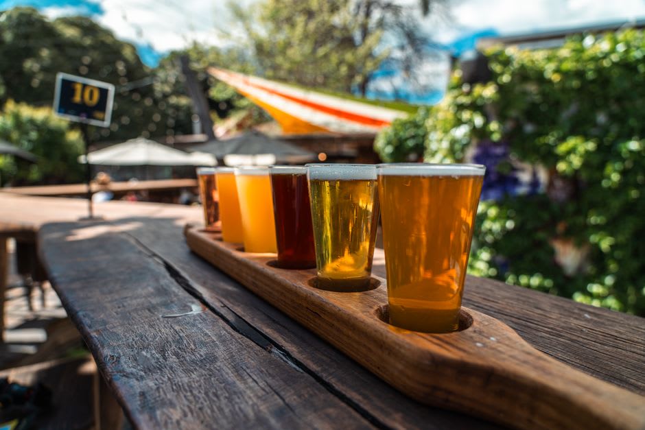 Craft beer flight on a wooden table at a Bangalore microbrewery in the evening