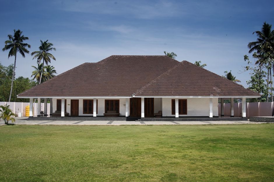 A colonial-era bungalow with a red tin roof set among tall deodar trees in Dalhousie