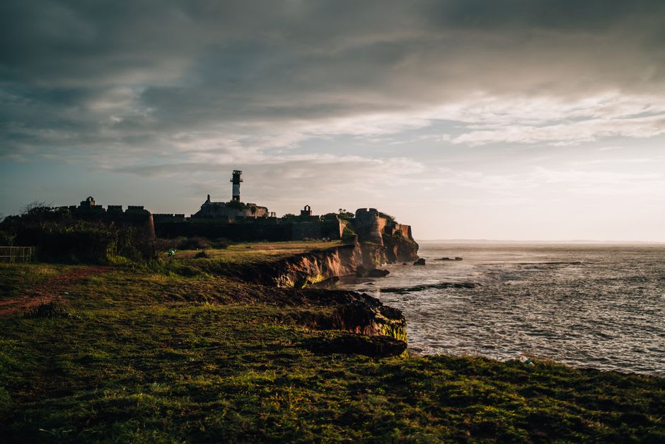 Cannons and crumbling ramparts of Diu Fort overlooking the Arabian Sea at sunset