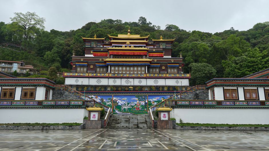 The golden-roofed Rumtek Monastery courtyard with young monks walking across it