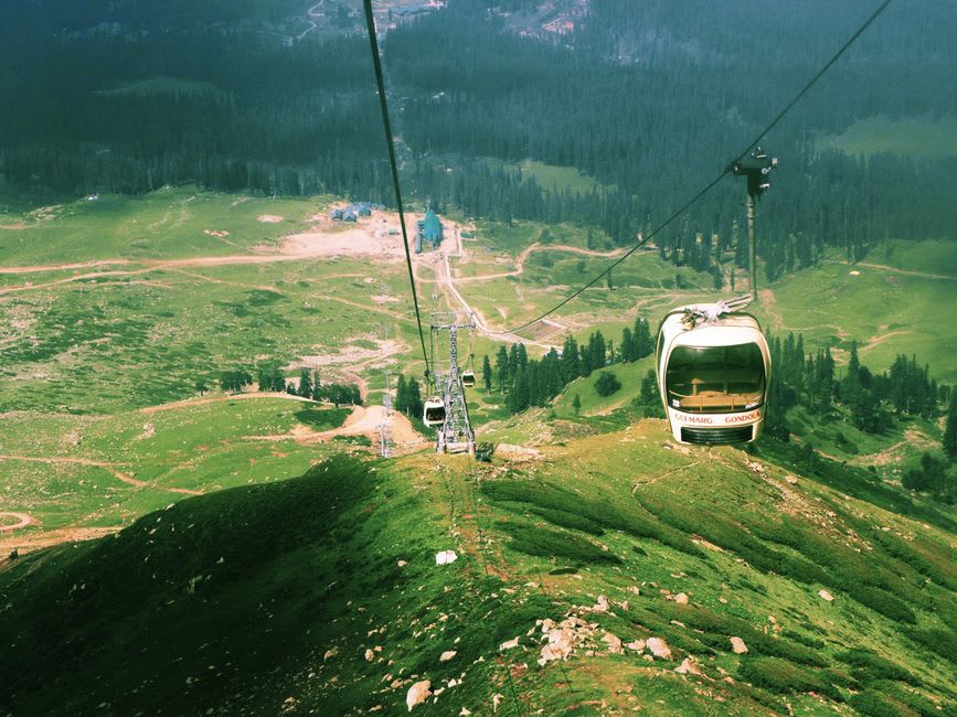 The Gulmarg Gondola cable car climbing above snow-covered slopes toward Apharwat Peak