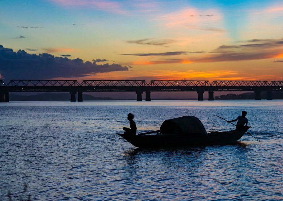 A wooden rowboat crossing the Brahmaputra toward the temple on Umananda Island