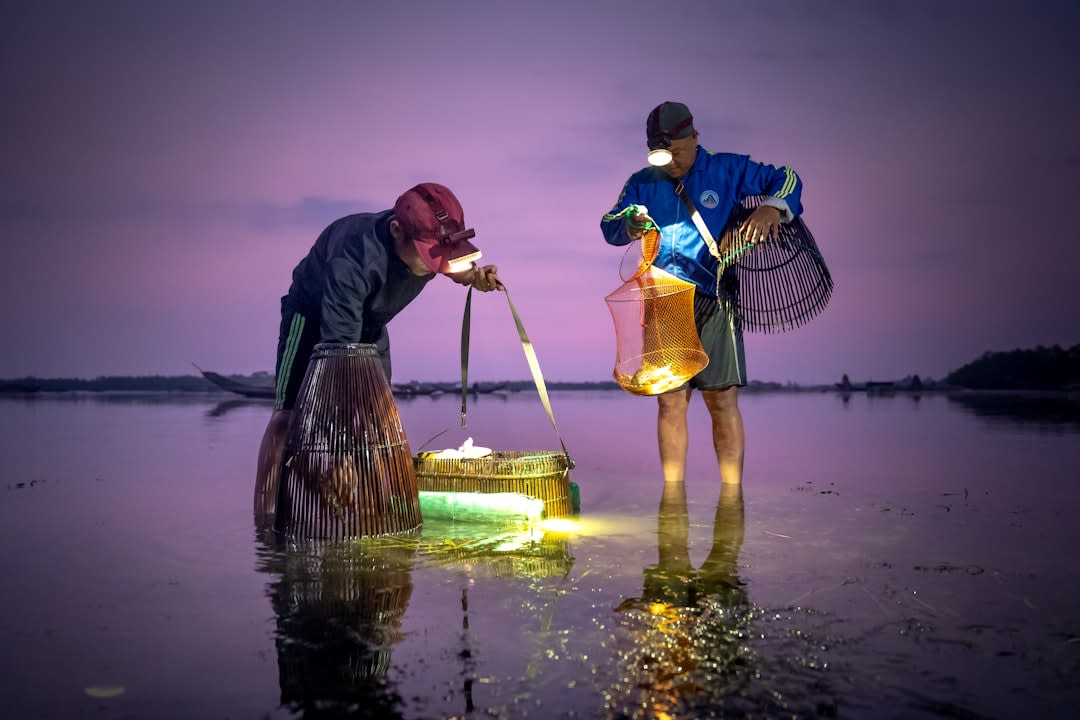 Bioluminescent plankton glowing blue around a kayak paddle at night near Havelock Island