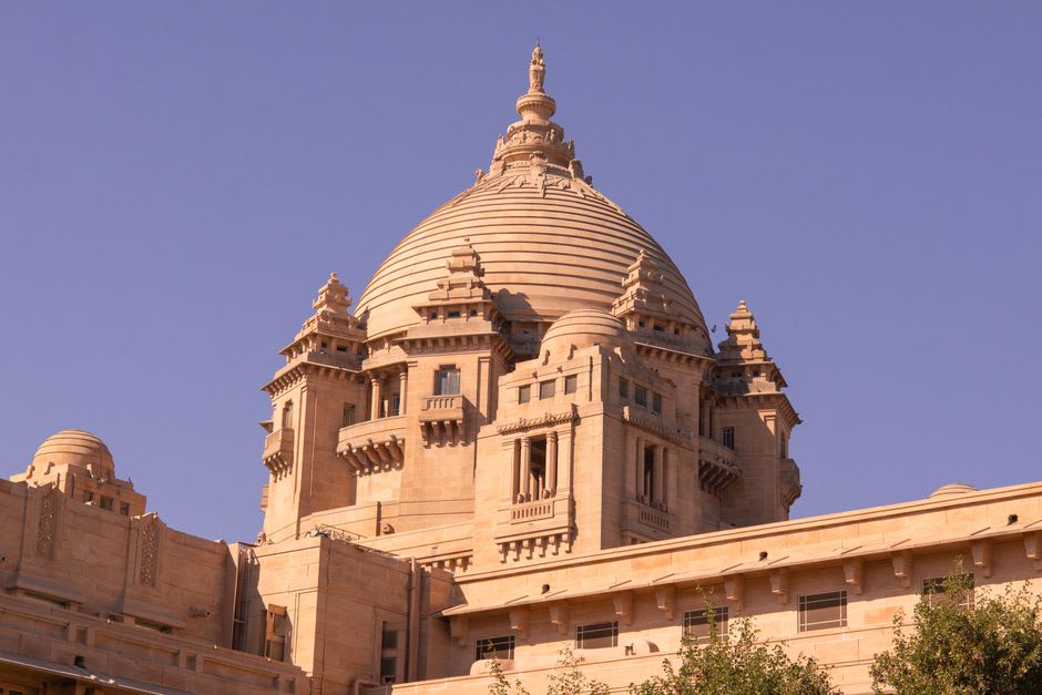 Umaid Bhawan Palace's sandstone facade glowing at sunset above Jodhpur