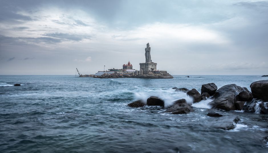 Sunrise breaking over the water at Kanyakumari with the Vivekananda Rock Memorial visible offshore