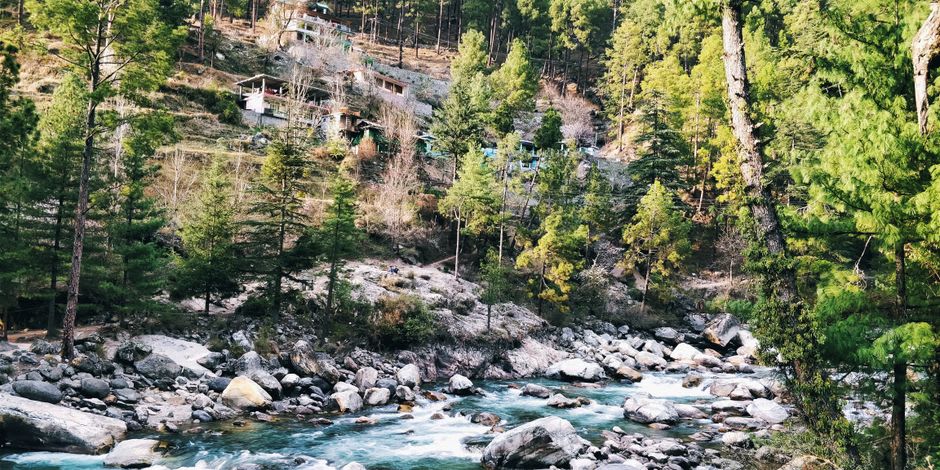 Colourful guesthouse balconies overlooking the turquoise Parvati river in Kasol
