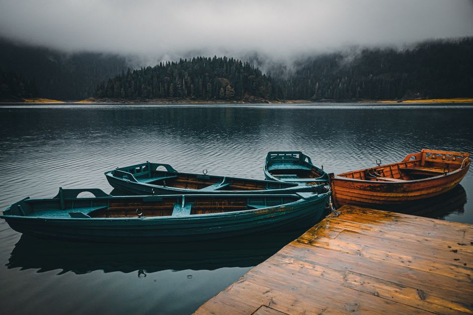 Wooden rowboats moored on the still, misty waters of Kodaikanal's star-shaped lake at sunrise