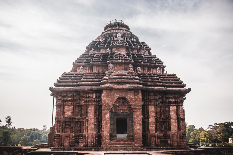 The full facade of the Konark Sun Temple glowing under a setting sun