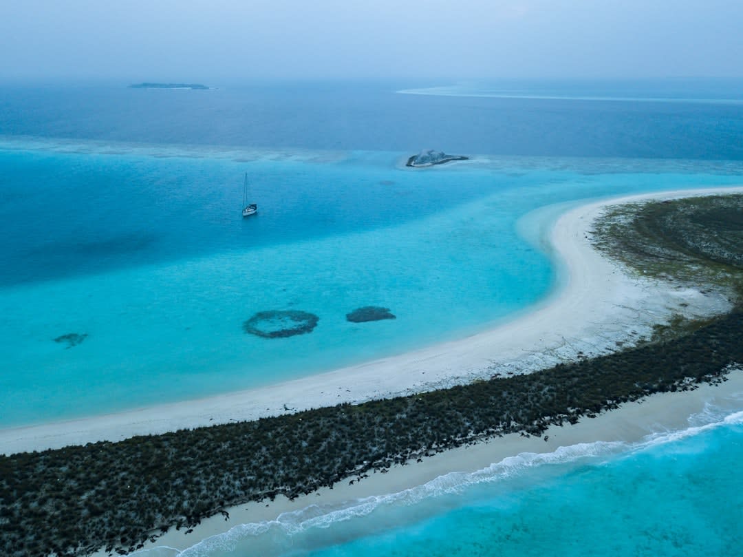 The narrow coral rim of Agatti Island surrounded by pale turquoise lagoon water