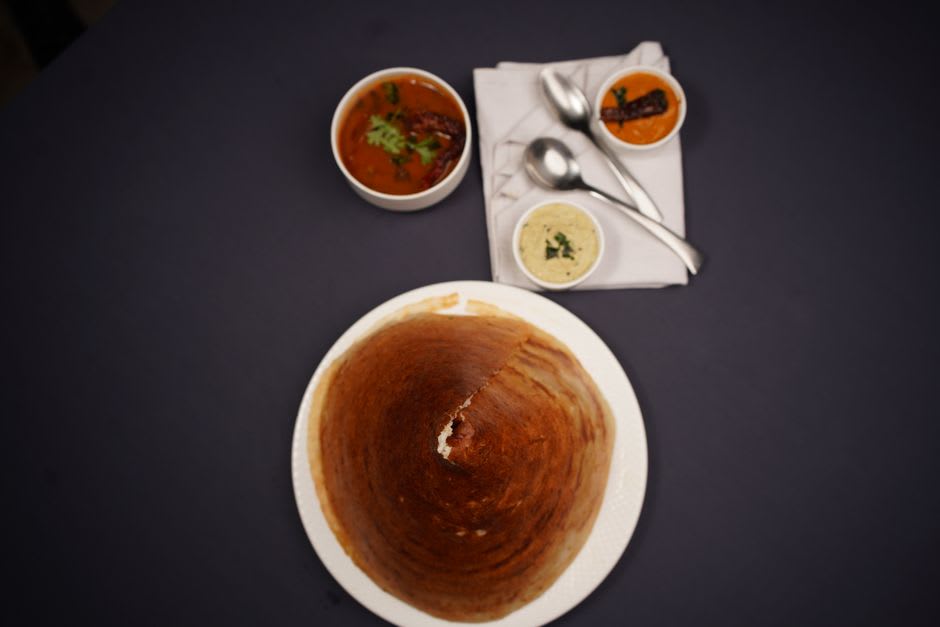 Mangalorean fish curry with kane fry and neer dosa served on a steel plate