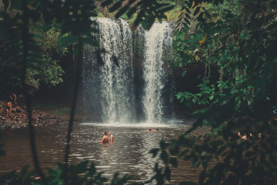 Water cascading down the rocks at Bee Falls near Pachmarhi, with bathers in the pool below