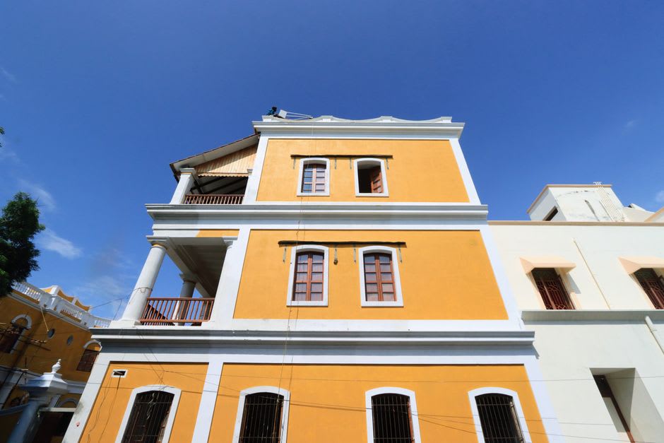 A quiet cobblestone street in Pondicherry's French Quarter lined with colonial villas and bougainvillea
